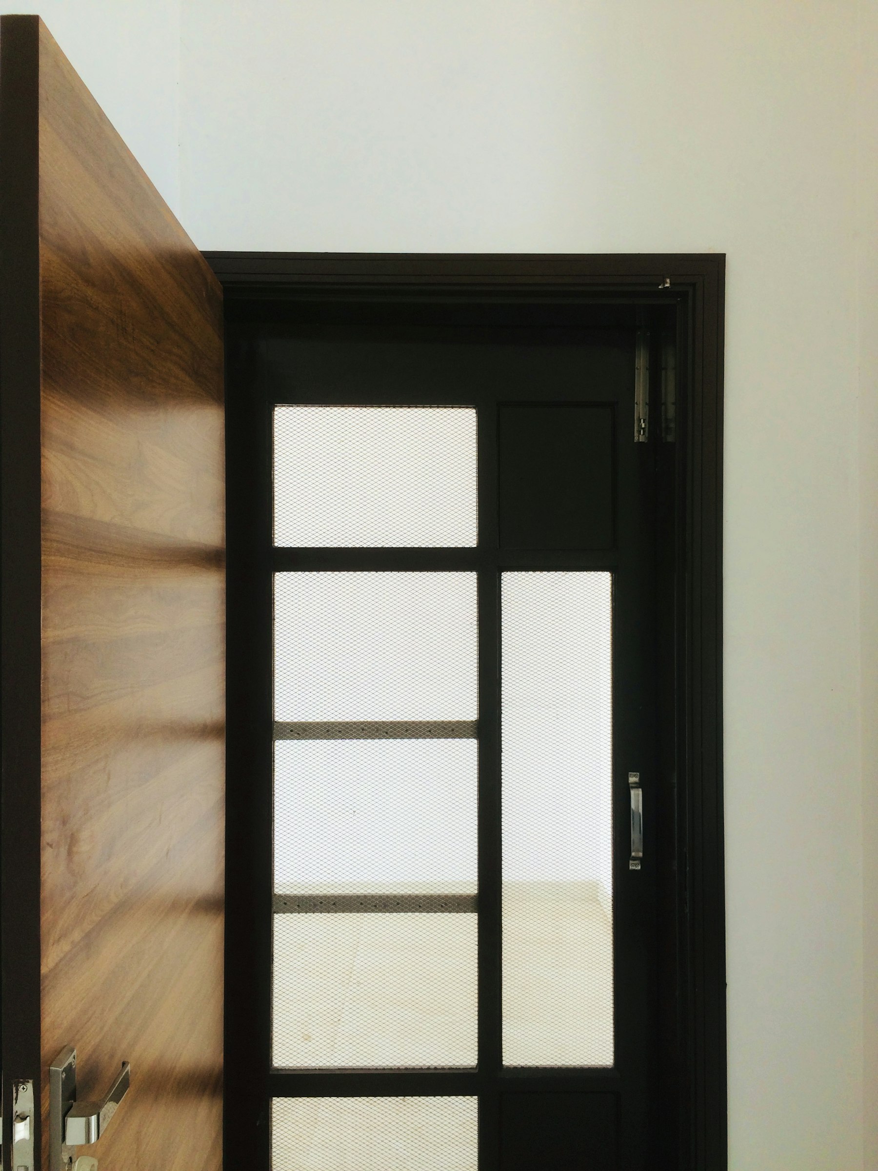 Solid wood entrance door with matte black frame